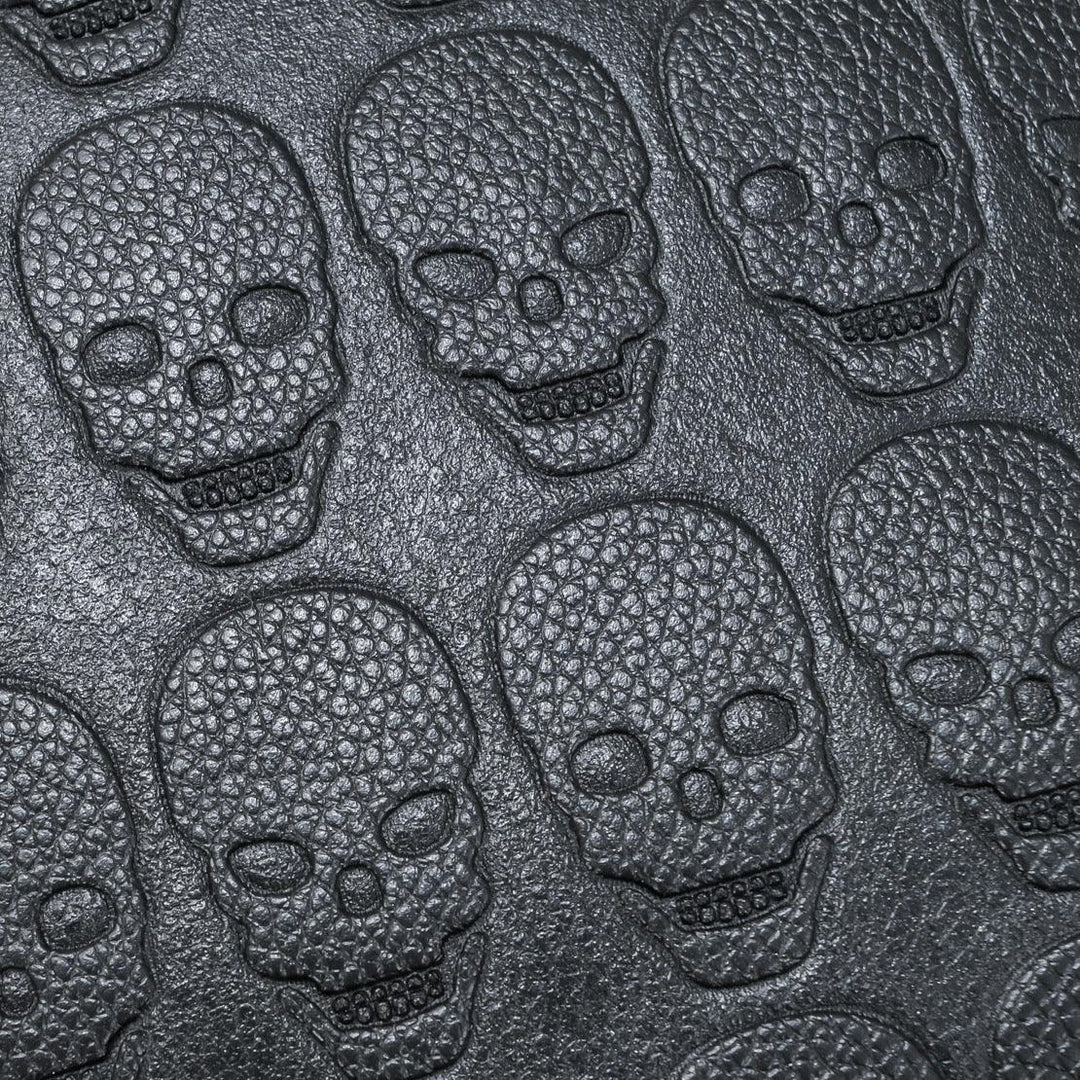 Close-up of textured black skull pattern embossed on a leather surface