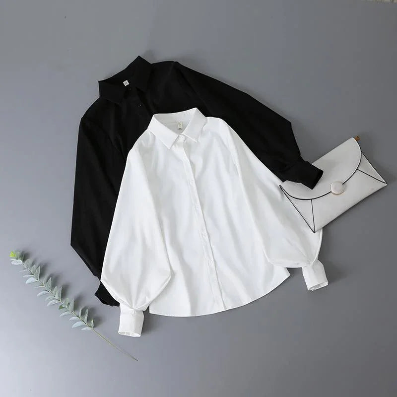 Black and white button-up shirts with puff sleeves and a white clutch on gray background