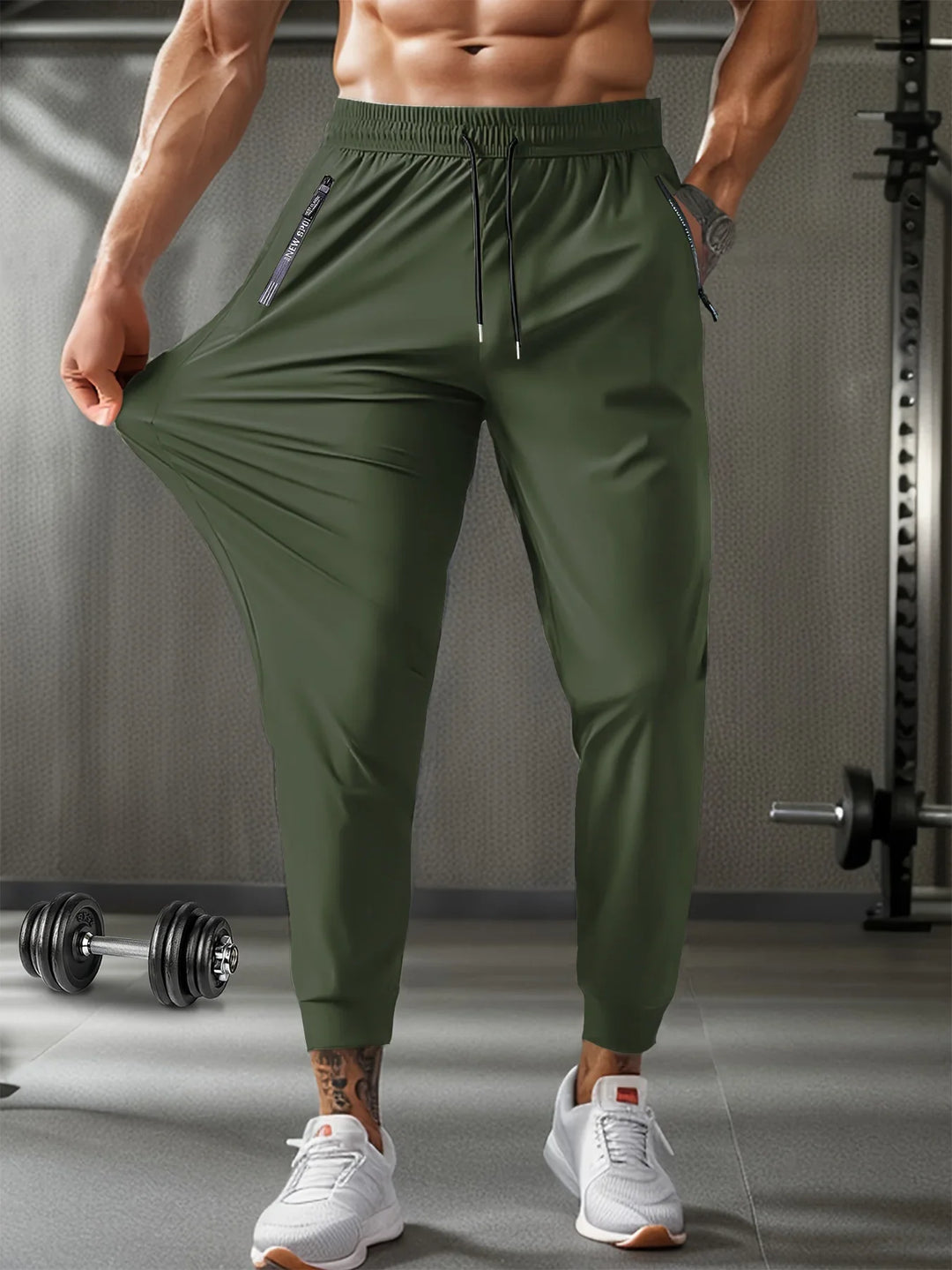 Man wearing olive green stretch gym pants with zipper pockets in a workout gym setting