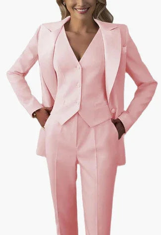 Woman wearing a stylish light pink tailored suit with blazer, vest, and trousers