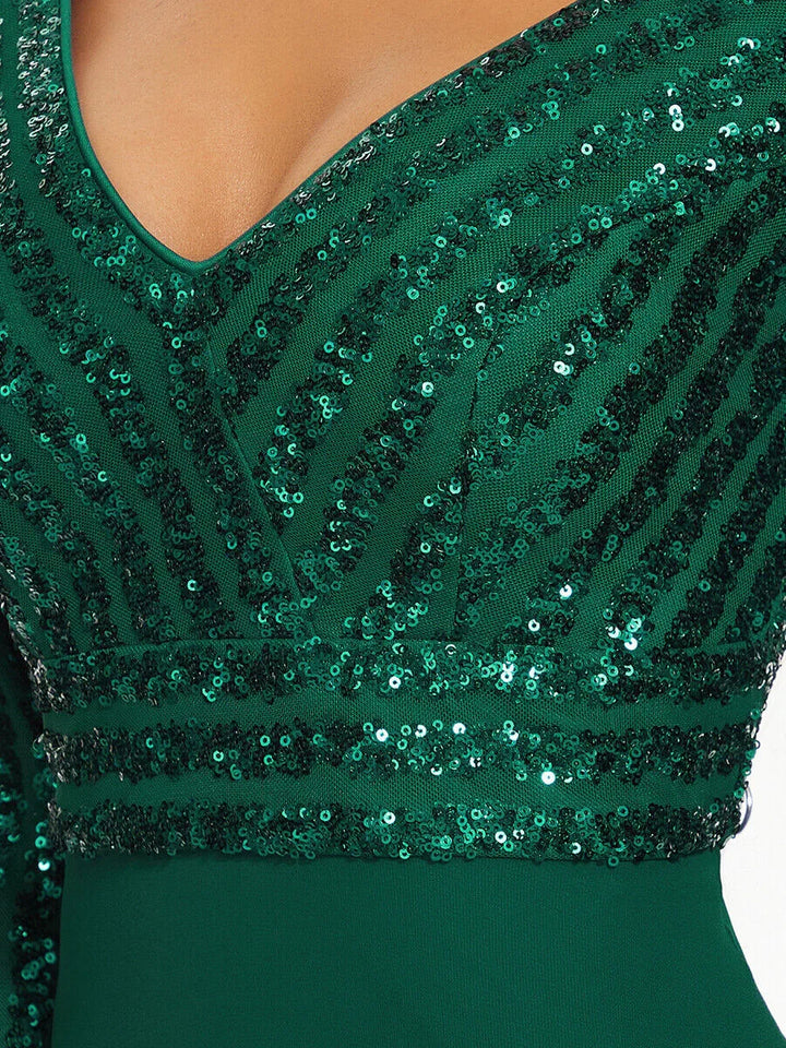 Close-up of green V-neck dress with glittering sequin stripes and fitted waist