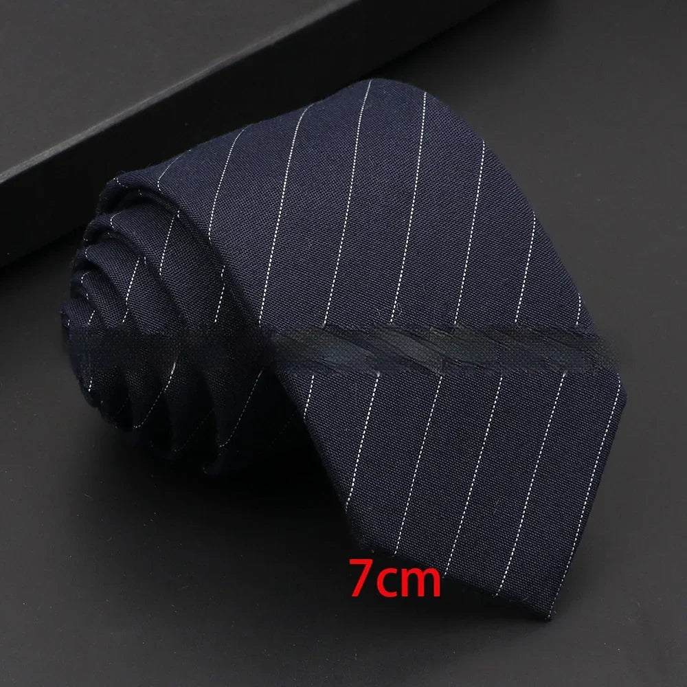 Rolled navy blue pinstripe necktie measuring 7cm wide on black surface