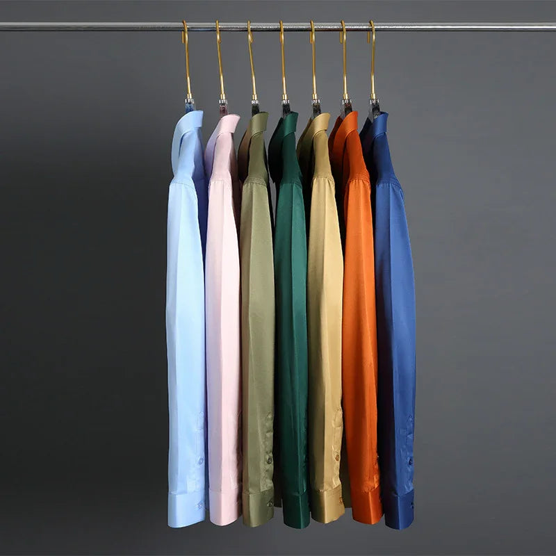 Seven colorful long-sleeve dress shirts hanging on gold hangers against dark gray background