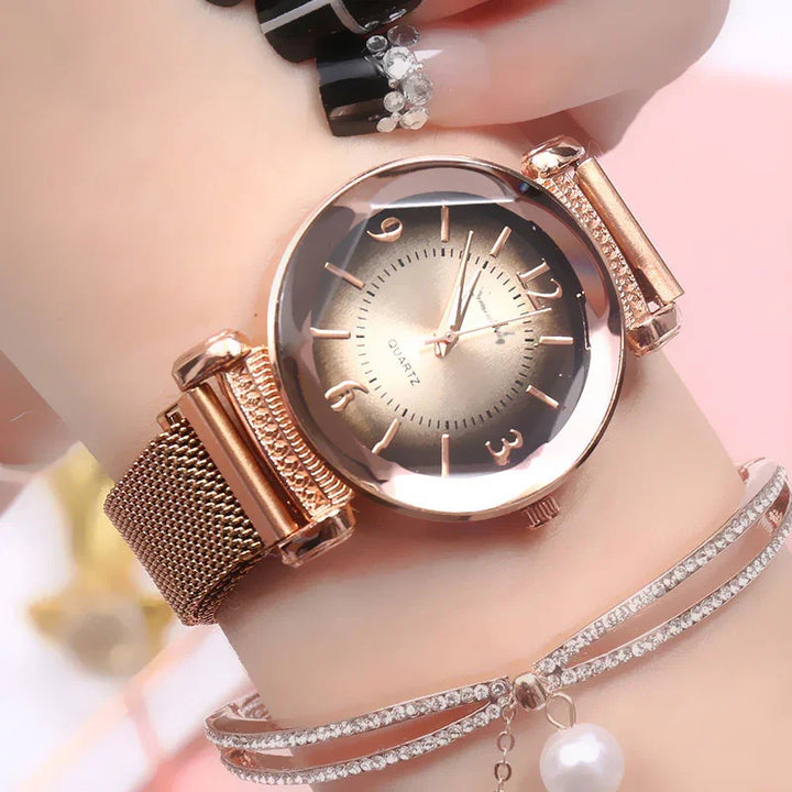 Rose gold quartz wristwatch with mesh strap and rhinestone accents on wrist with crystal bracelet
