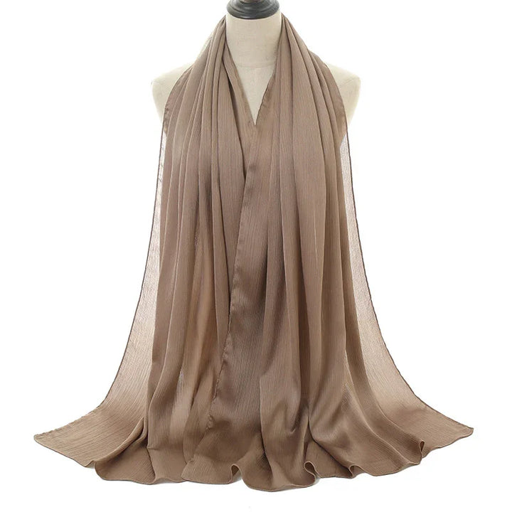 Beige pleated chiffon scarf displayed on a mannequin against white background