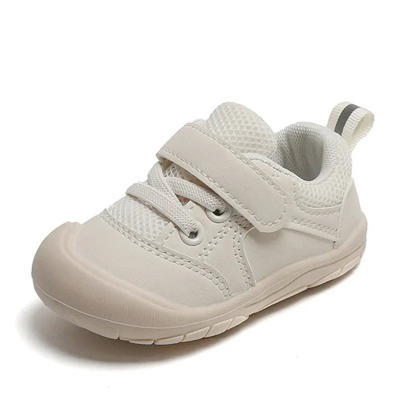 White toddler sneaker with mesh tongue, hook-and-loop strap, and flexible rubber sole