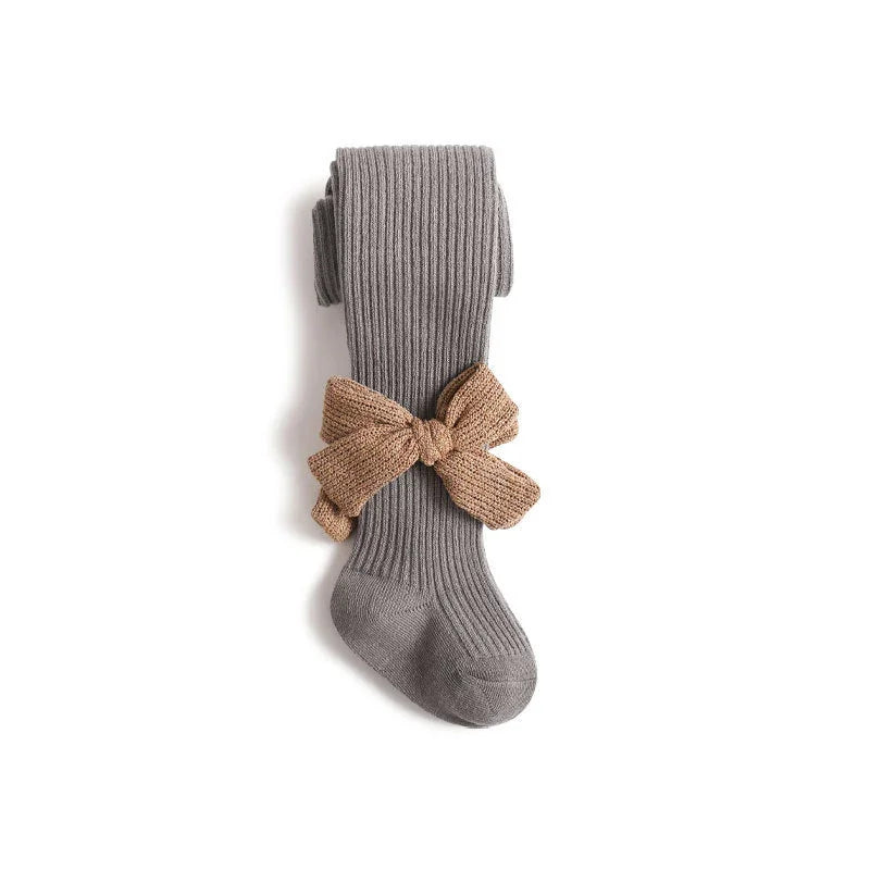 Gray ribbed knit tights with a large brown knitted bow on a white background