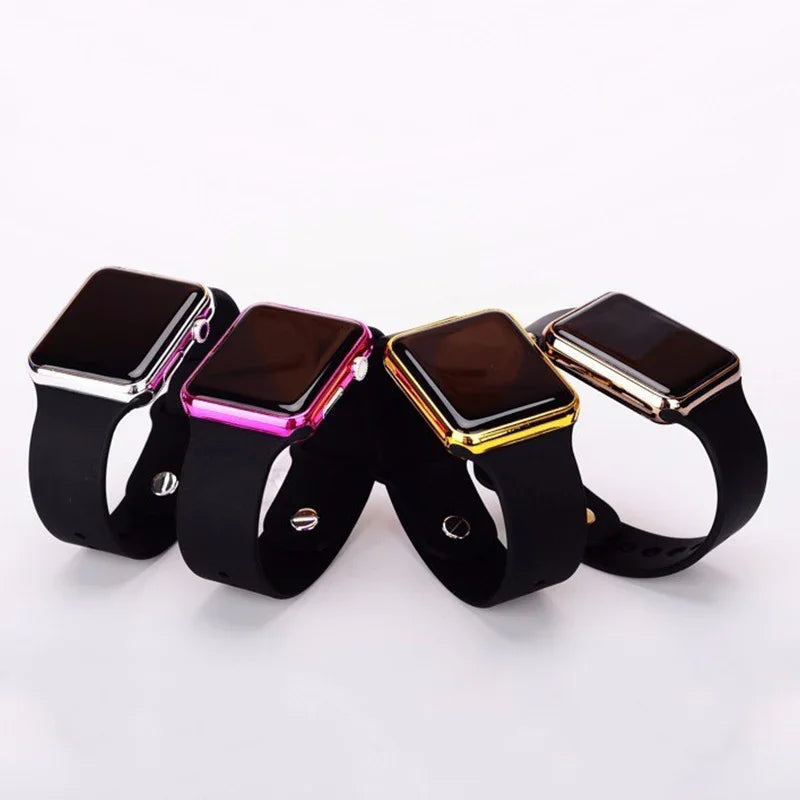 Four smartwatches with black bands and colorful metallic cases in silver, pink, gold, and rose gold on white background