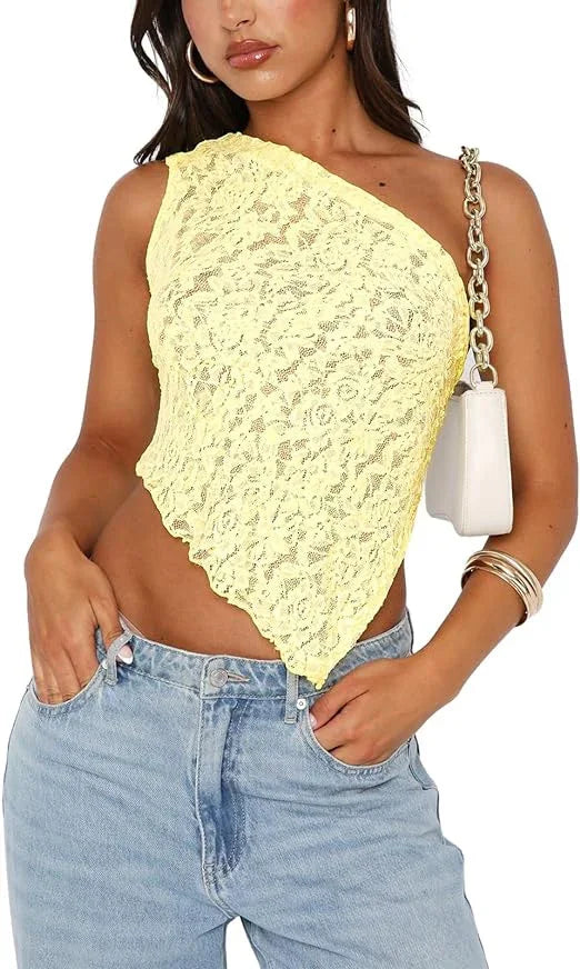 Woman wearing a yellow lace one-shoulder crop top with light blue jeans and silver hoop earrings