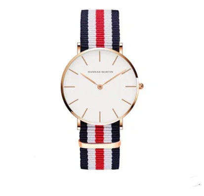 Minimalist wristwatch with white dial, rose gold case, and navy, white, red striped nylon strap