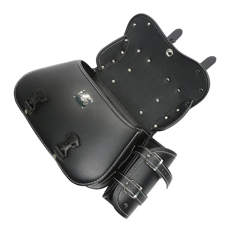 Black leather motorcycle saddlebag with metal studs and buckled straps, open view