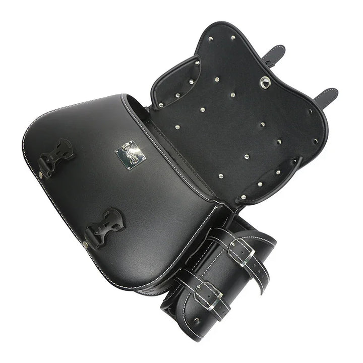 Black leather motorcycle saddlebag with metal studs and buckled straps, open view