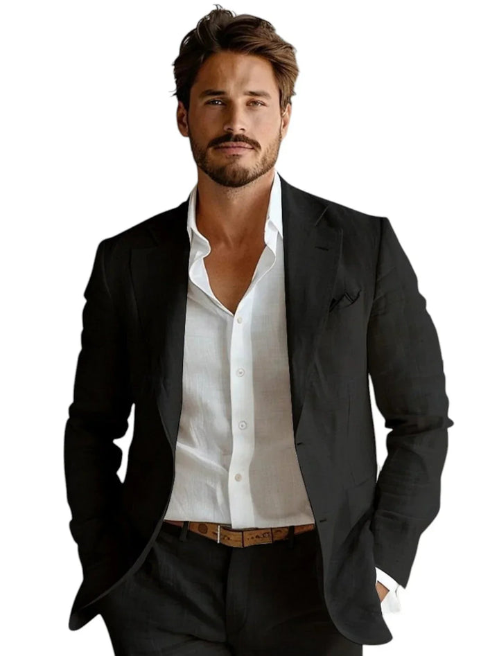 Man wearing black suit jacket over white dress shirt with brown belt, hands in pockets