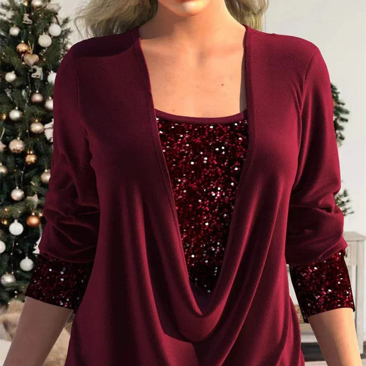 Woman wearing burgundy sequin top layered with matching long-sleeve draped cardigan near decorated Christmas tree