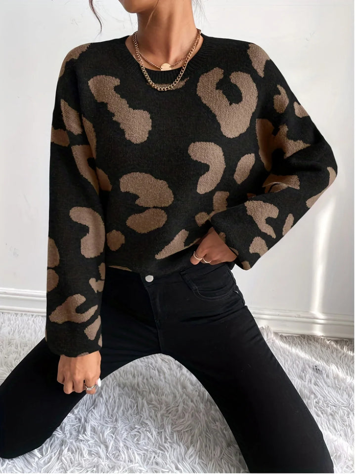 Woman wearing black and brown leopard print sweater with black jeans against white background