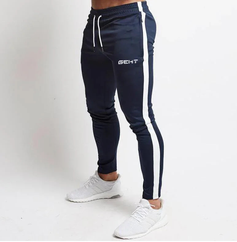 Man wearing navy blue slim-fit joggers with white side stripes and white sneakers