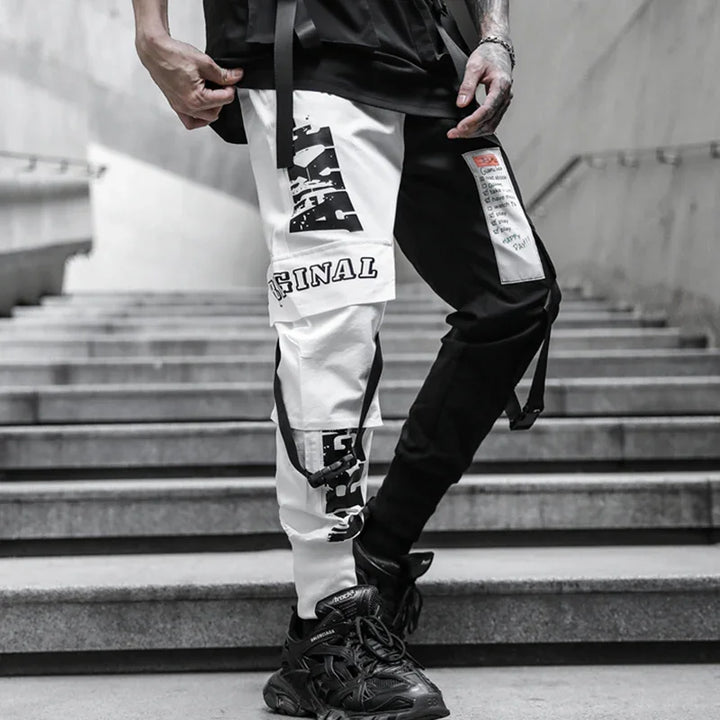 Streetwear style black and white cargo pants with graphic patches and black sneakers on urban stairs