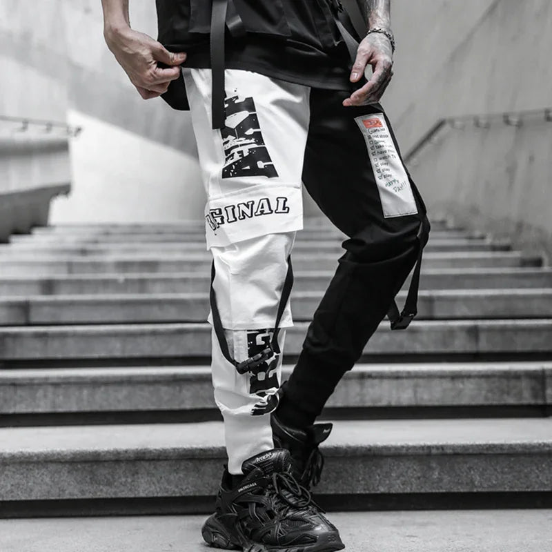 Urban fashion black and white patchwork cargo pants with text prints and black sneakers on concrete stairs