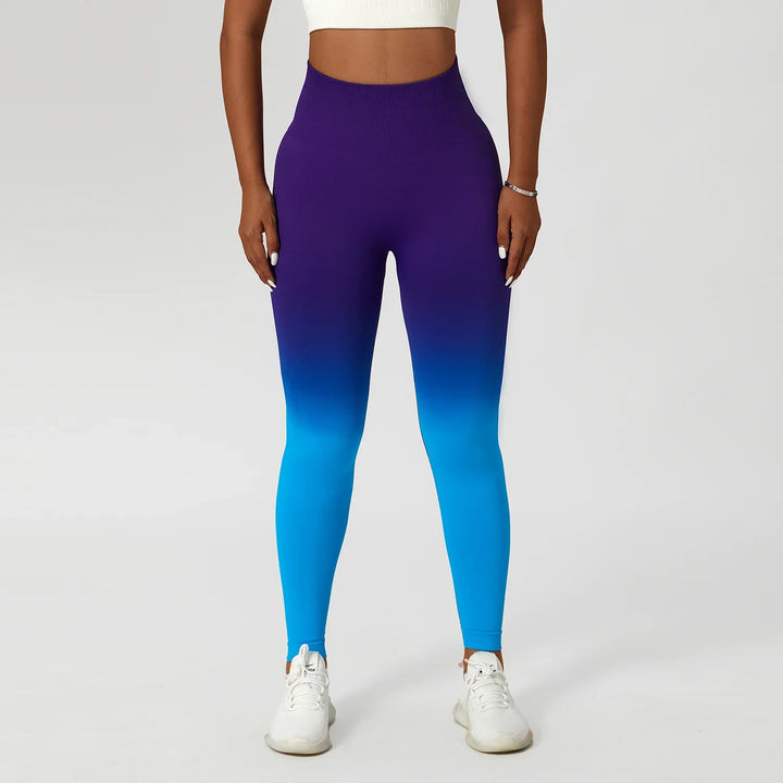 Woman wearing blue to purple ombre seamless leggings and white crop top, fitness wear