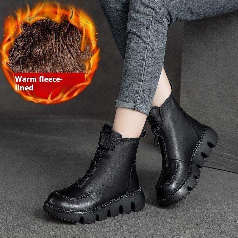 Black warm fleece-lined winter boots with thick rubber soles and zipper worn with rolled gray jeans