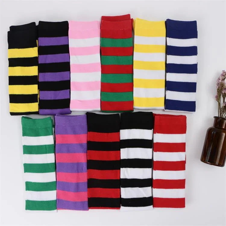 Colorful striped socks in various bright colors neatly arranged with a brown vase and dried flowers on white background