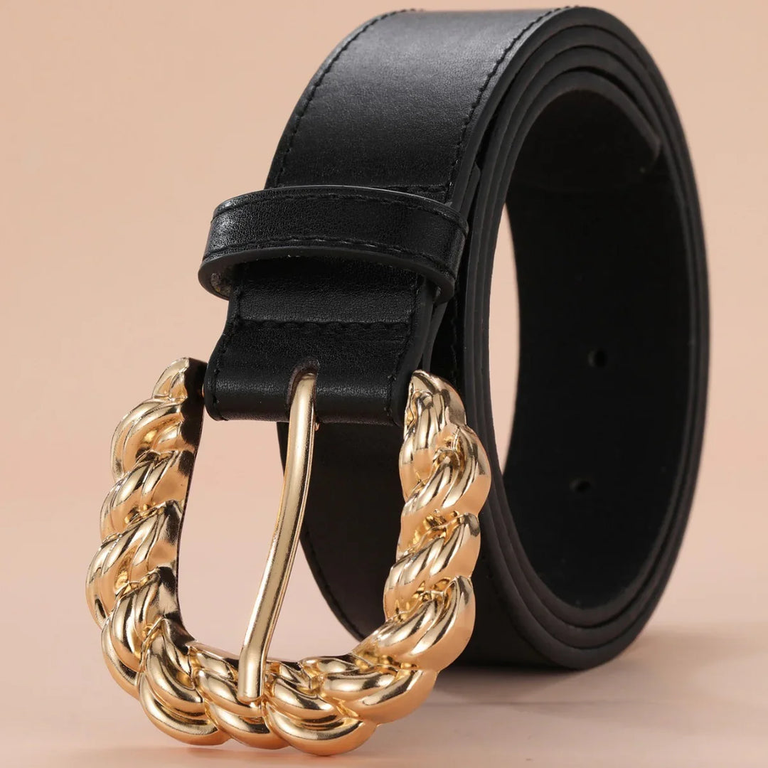 Black leather belt with a gold twisted rope design buckle on beige background
