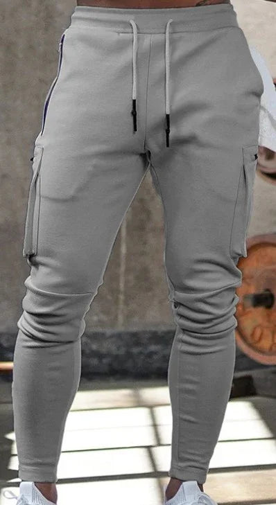 close-up of gray slim-fit cargo jogger pants with drawstring waist and side pockets worn in gym setting