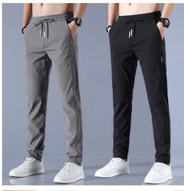 Men's casual slim-fit jogger pants in gray and black, paired with white sneakers and smartwatches