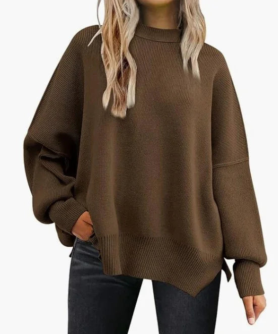 Woman wearing oversized brown knit sweater with ribbed cuffs and hem, paired with black jeans