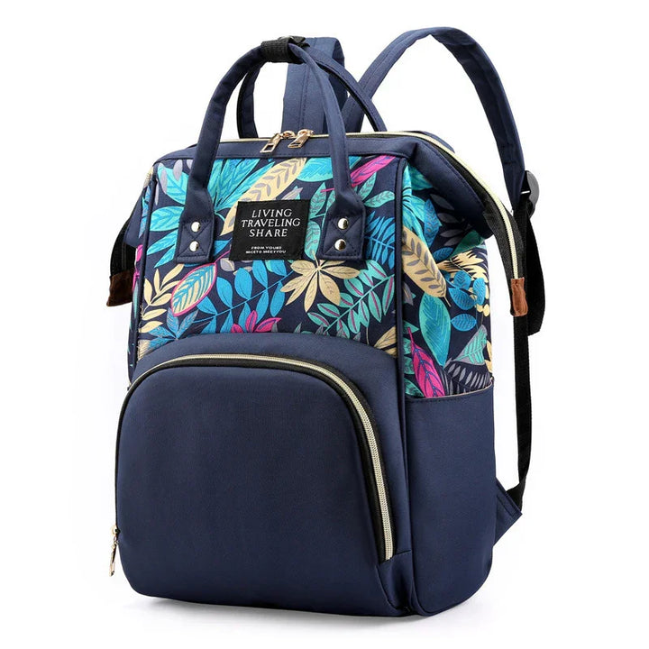 Navy blue backpack with multicolor tropical leaf pattern and front zip pocket for travel and daily use