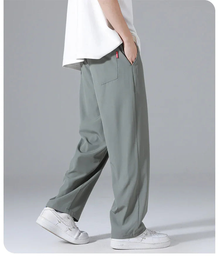 Side view of person wearing loose gray pants with back pocket and white sneakers