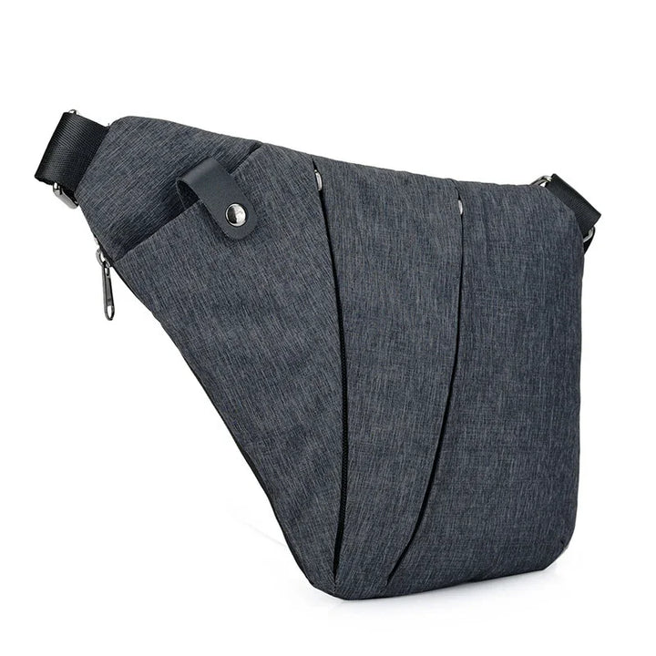 dark gray sling bag with multiple zippered compartments and adjustable strap