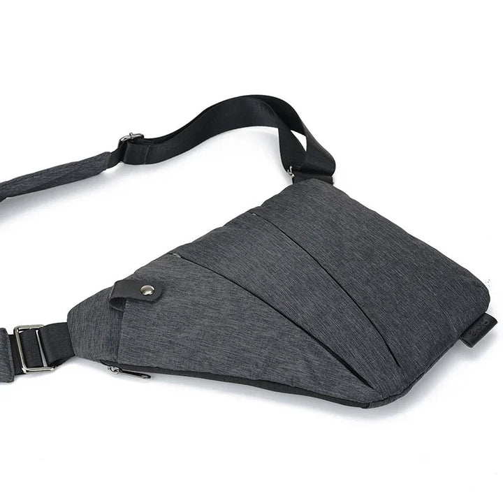 Modern grey crossbody sling bag with adjustable strap and zippered compartments on white background