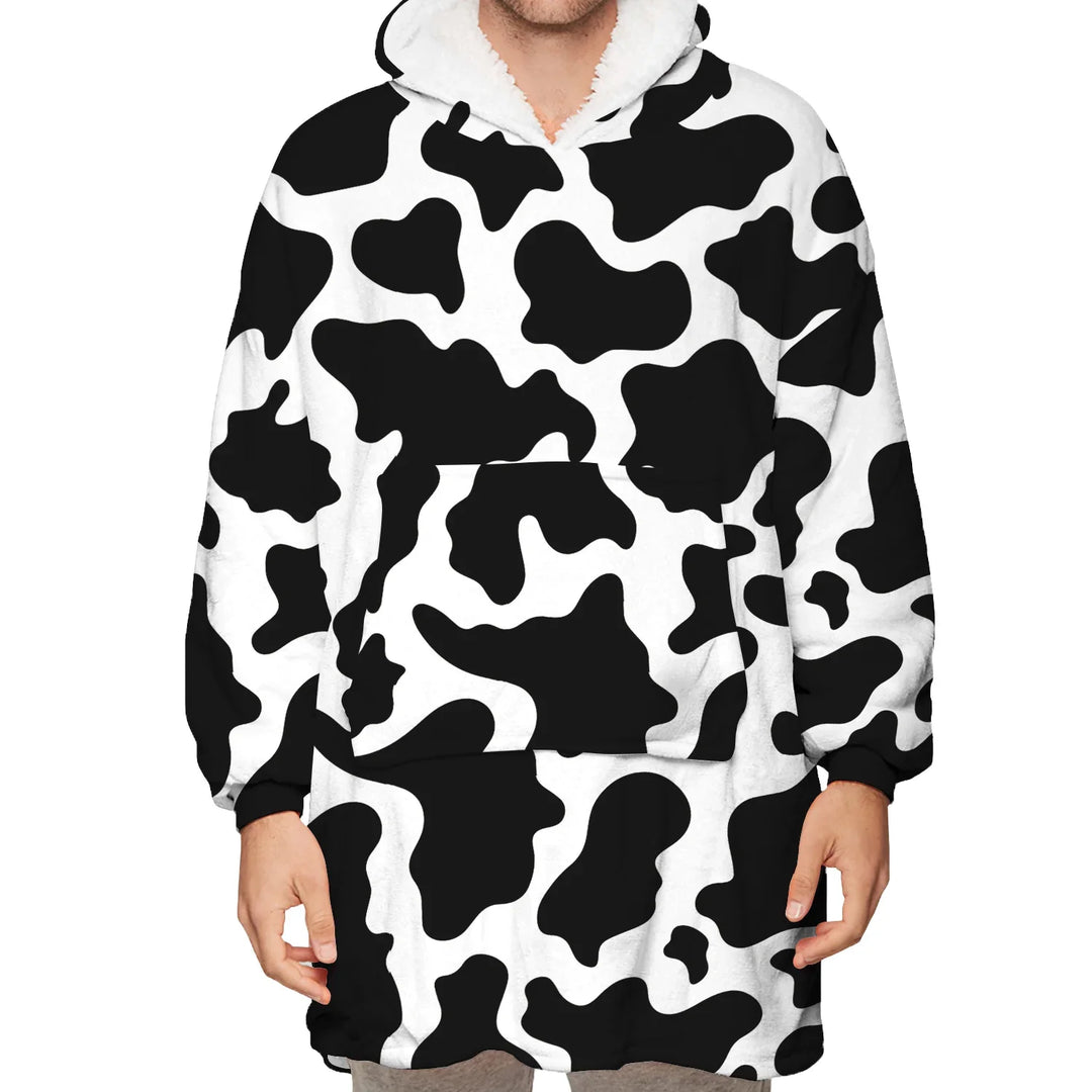 Person wearing oversized plush hoodie with black and white cow print and front pocket