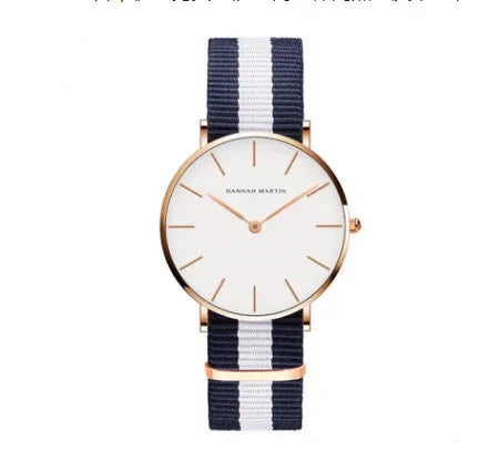 Minimalist wristwatch with white dial, rose gold case, and navy blue and white striped fabric strap