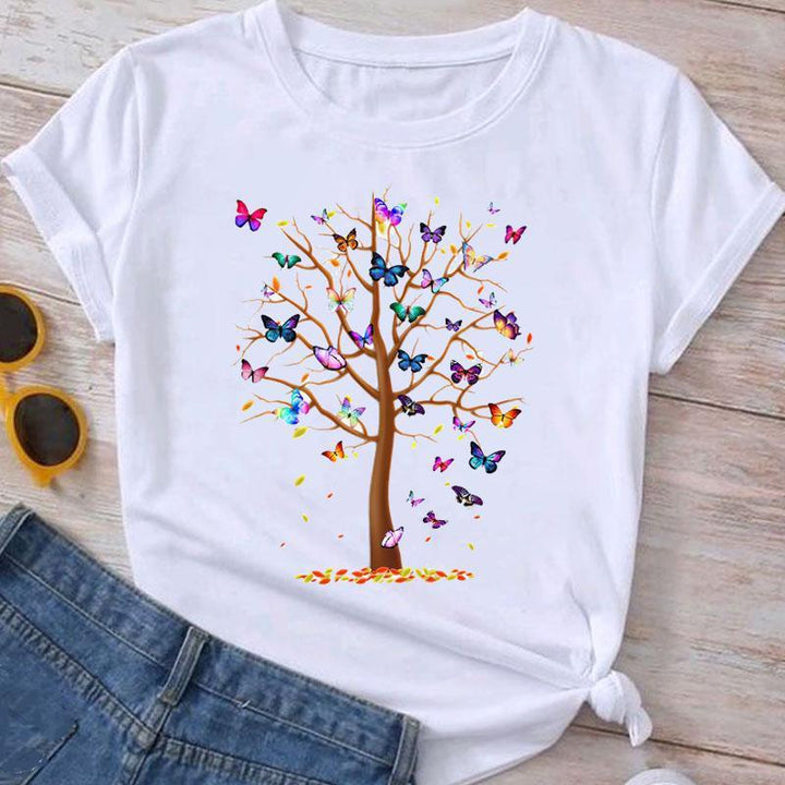 White T-shirt with colorful butterfly tree print, paired with denim shorts and sunglasses on wooden floor