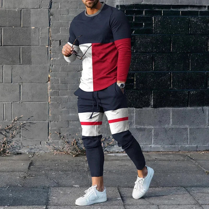Man wearing stylish color-blocked navy, red, and white tracksuit with white sneakers on urban street