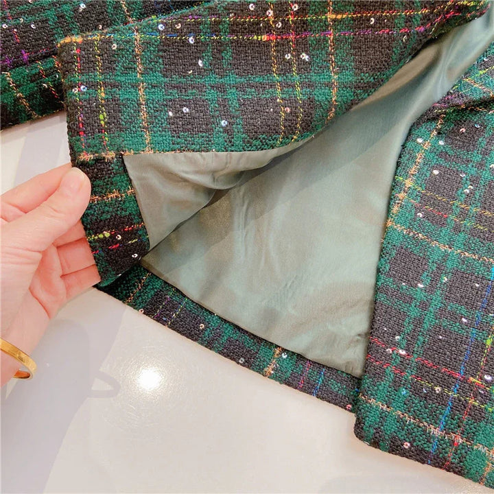 Hand holding green plaid tweed fabric jacket with sequin details showing inner smooth lining