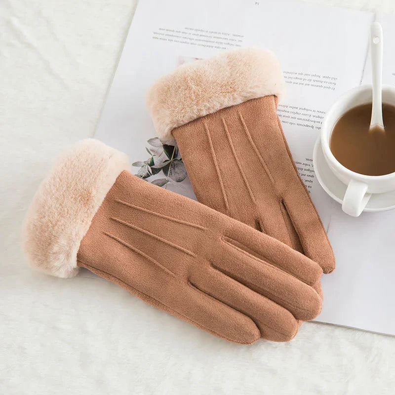 Pair of brown suede gloves with plush fur cuffs on white surface next to coffee cup and paper