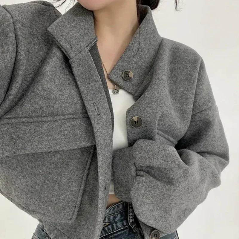 Close-up of woman wearing a grey wool button-up jacket with puff sleeves and collar