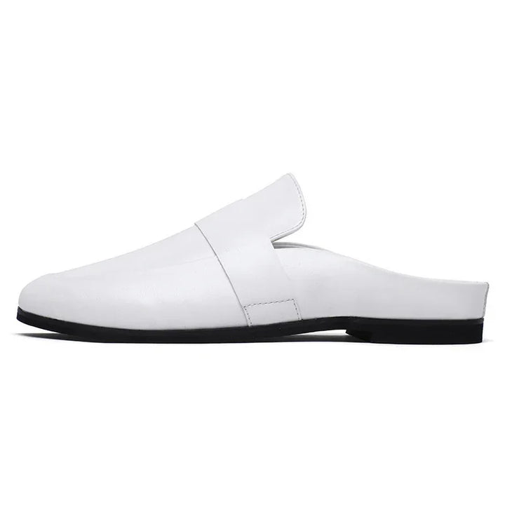 Minimalist white leather mule shoe with black sole on white background