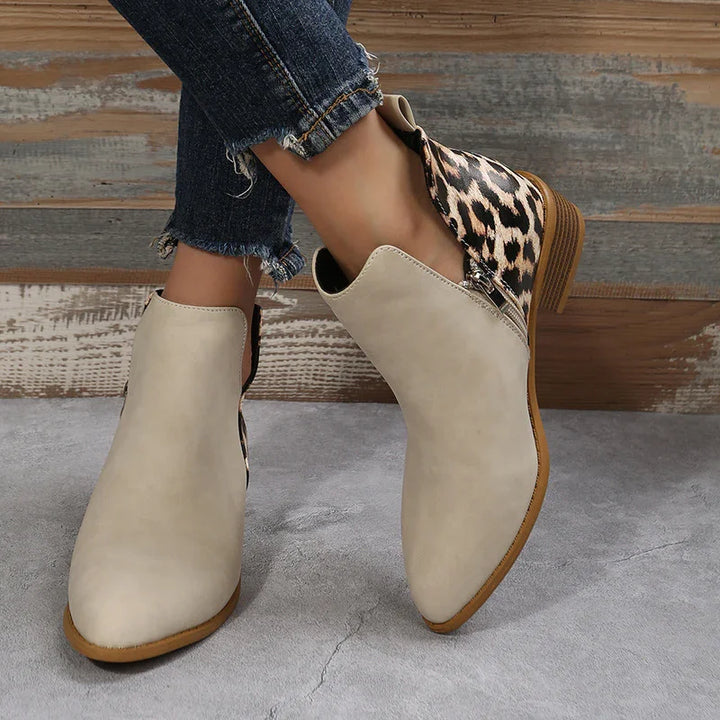 Women's beige ankle boots with leopard print heel detail and side zipper, worn with frayed hem jeans