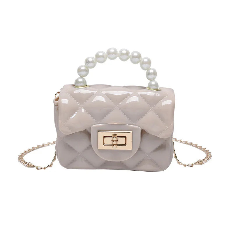 Small quilted beige handbag with pearl handle and gold chain strap