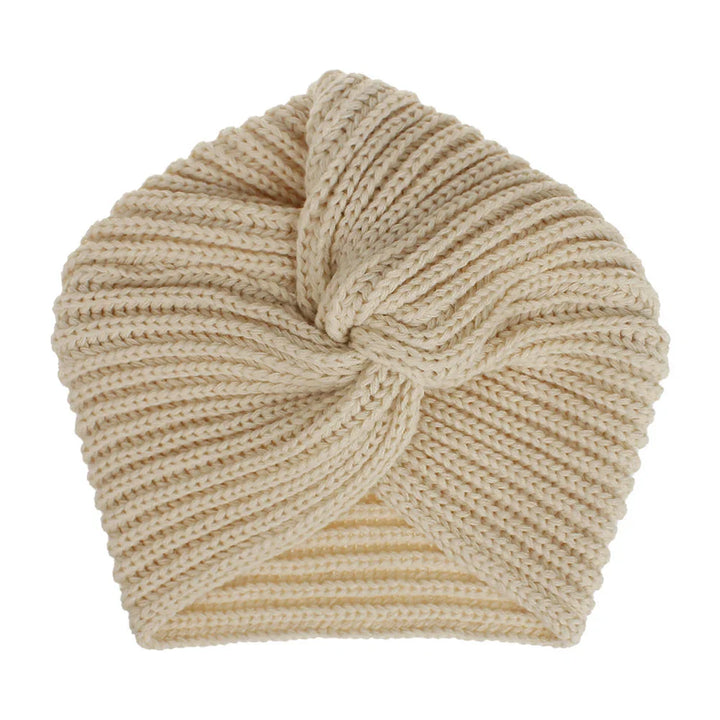 Beige knitted turban hat with twisted front design on white background