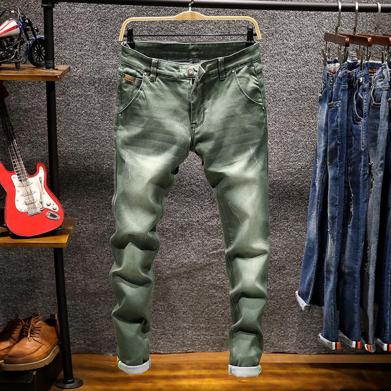 Green slim-fit casual jeans with rolled cuffs on hanger in stylish men's clothing store