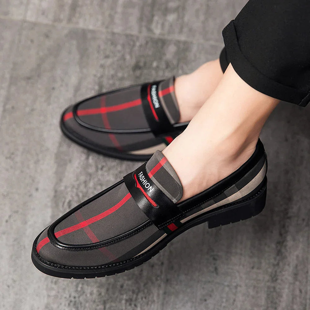 Men's black and red plaid slip-on fashion loafers worn with black pants on gray floor