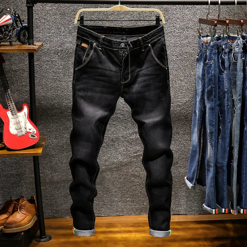 Black slim-fit jeans hanging on a wooden hanger in a stylish clothing store display