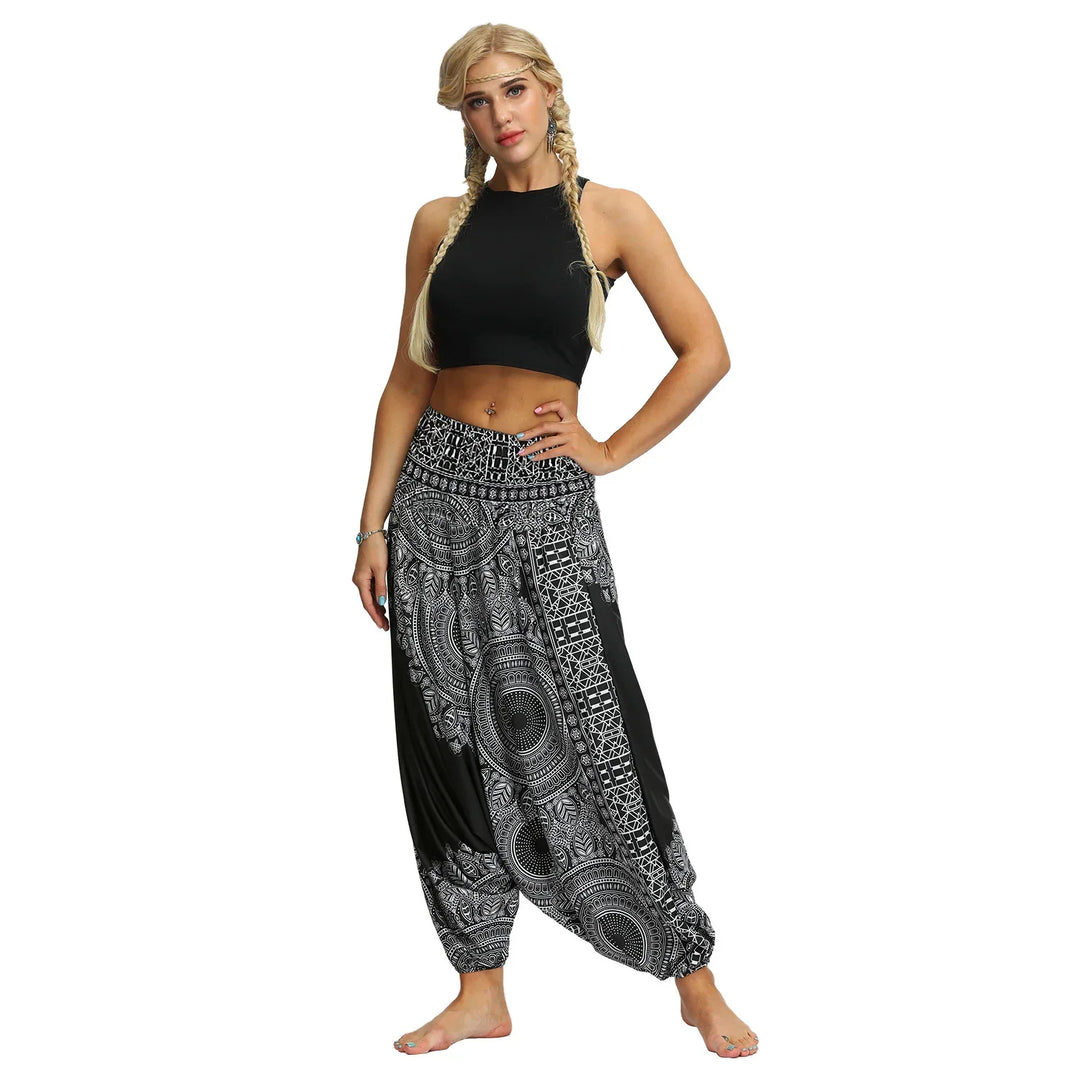 Blonde woman in black crop top and black and white patterned harem pants on white background