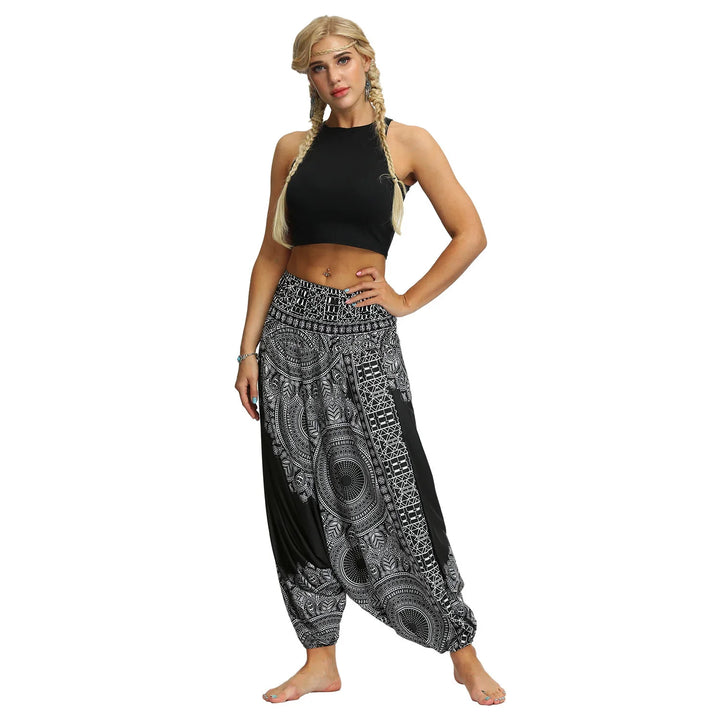 Blonde woman in black crop top and black and white patterned harem pants on white background