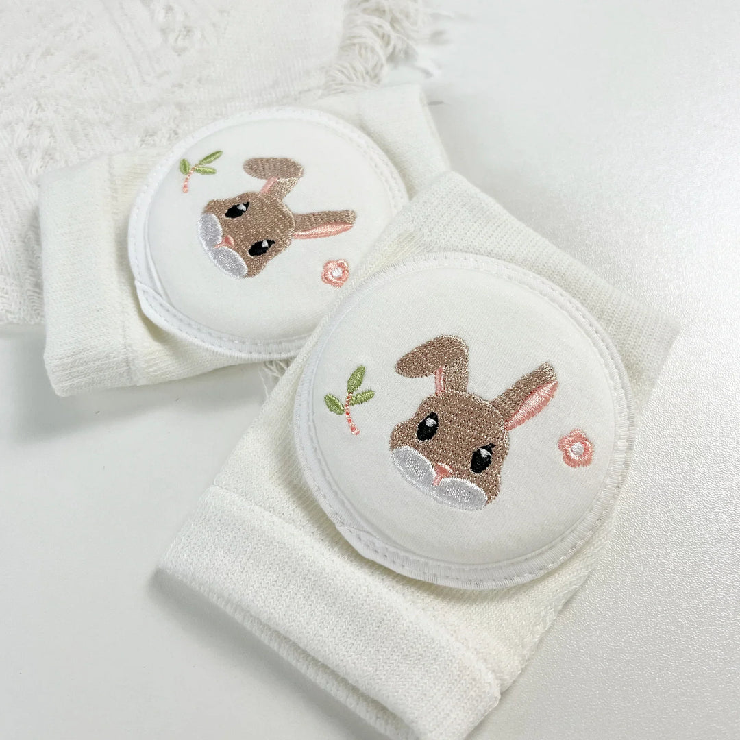 White baby knee pads with embroidered cute bunny and floral design on soft fabric